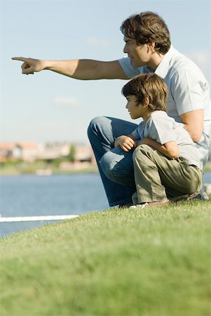 simsearch:632-01380362,k - Father and son sitting by edge of water, looking toward distance Foto de stock - Royalty Free Premium, Número: 632-01380659