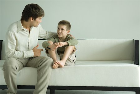 simsearch:632-01380362,k - Father and son sitting on sofa, talking Foto de stock - Royalty Free Premium, Número: 632-01380665