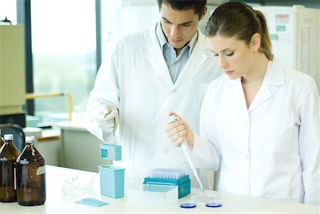 scientists standing together - Female lab worker dropping solution into Petri dish, standing next to male colleague Stock Photo - Premium Royalty-Free, Code: 632-01611954