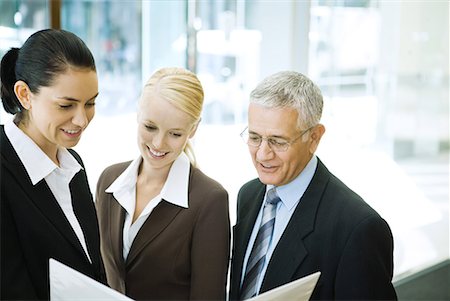 simsearch:632-01155400,k - Business associates looking at binder together, waist up Stock Photo - Premium Royalty-Free, Code: 632-01612022