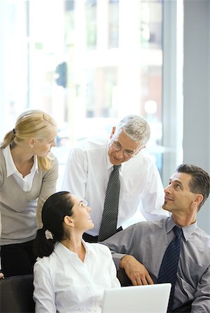 simsearch:695-03376535,k - Four business associates smiling at each other, one using laptop computer Stock Photo - Premium Royalty-Free, Code: 632-01612105