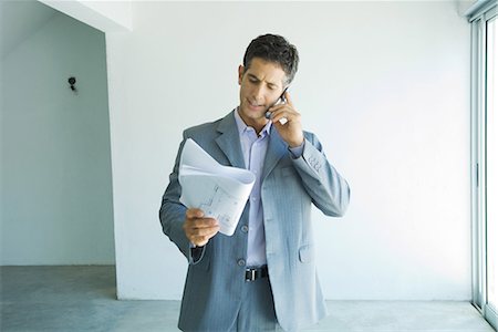 realtor (male) - Man in suit looking at blueprints, using cell phone Stock Photo - Premium Royalty-Free, Code: 632-01612710