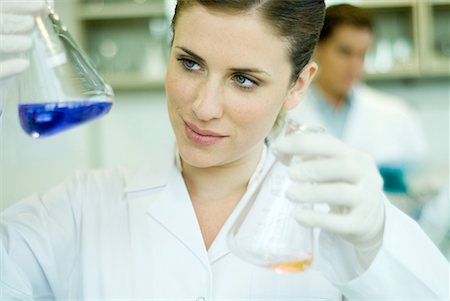 researcher - Young woman working in scientific laboratory, holding up flasks Stock Photo - Premium Royalty-Free, Code: 632-01612786