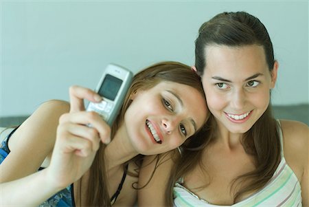 simsearch:632-01271195,k - Young woman photographing self with friend, holding up cell phone Fotografie stock - Premium Royalty-Free, Codice: 632-01612844