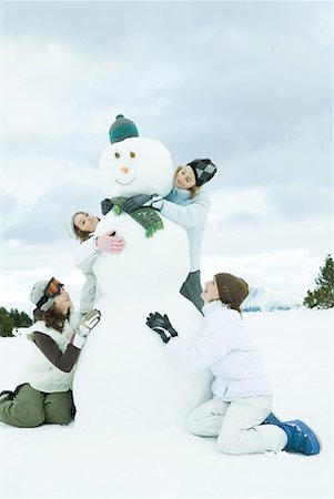 simsearch:695-05766599,k - Jeunes amis embrassant le bonhomme de neige, souriant, pleine longueur Photographie de stock - Premium Libres de Droits, Code: 632-01612966