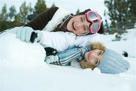 simsearch:695-03389446,k - Deux jeunes amis couché dans la neige, souriant à la caméra, l'un sur l'autre Photographie de stock - Premium Libres de Droits, Code: 632-01612961