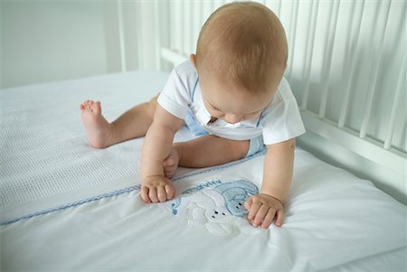 Baby in crib, looking at bunnies on blanket Stock Photo - Premium Royalty-Free, Code: 632-01636883