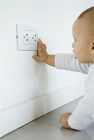 dangerous electrical pictures - Baby reaching for electrical outlet Stock Photo - Premium Royalty-Free, Code: 632-01636989