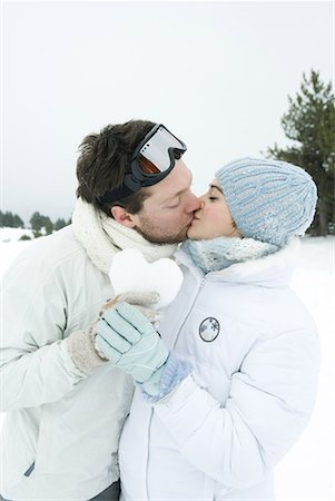 simsearch:633-05401372,k - Young couple kissing, holding heart made of snow together, eyes closed, portrait Stock Photo - Premium Royalty-Free, Code: 632-01638435