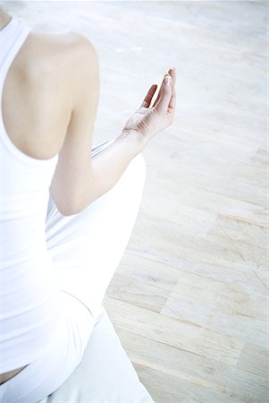 Woman sitting in lotus position, cropped rear view Stock Photo - Premium Royalty-Free, Code: 632-01638648