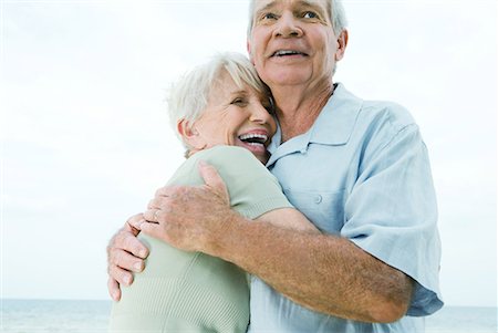 Senior couple hugging, woman laughing, low angle view Stock Photo - Premium Royalty-Free, Code: 632-01638720