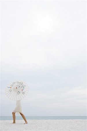 simsearch:696-03402939,k - Woman standing on beach, upper body hidden by parasol, full length, side view Stock Photo - Premium Royalty-Free, Code: 632-01638825