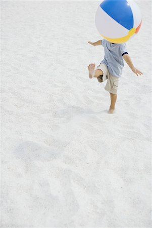 simsearch:695-05768252,k - Boy kicking beach ball on beach, head hidden by ball, high angle view, full length Fotografie stock - Premium Royalty-Free, Codice: 632-01638832