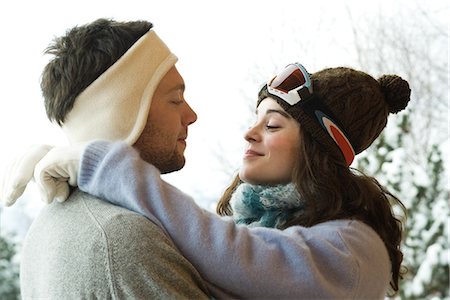 simsearch:632-03779625,k - Young couple in winter clothing, woman with arms around man's neck, side view Stock Photo - Premium Royalty-Free, Code: 632-01785069