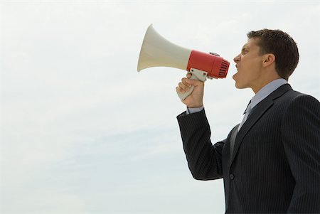 dominant man - Young businessman shouting into megaphone, side view Stock Photo - Premium Royalty-Free, Code: 632-01785088