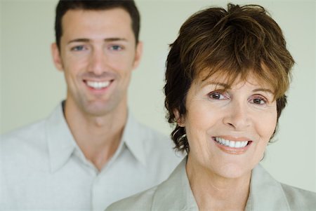 senior woman young man two people - Senior woman in front of adult son, both smiling at camera, focus on foreground Stock Photo - Premium Royalty-Free, Code: 632-01785129