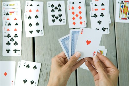 paciência - Woman playing card game, cropped view of hands Foto de stock - Royalty Free Premium, Número: 632-01785181