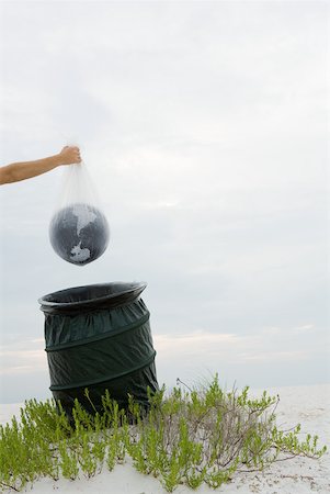 fragile world - Person holding globe in plastic bag over garbage can, cropped view Stock Photo - Premium Royalty-Free, Code: 632-01785199