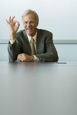 Businessman making OK hand gesture and smiling at camera Stock Photo - Premium Royalty-Free, Code: 632-01785261