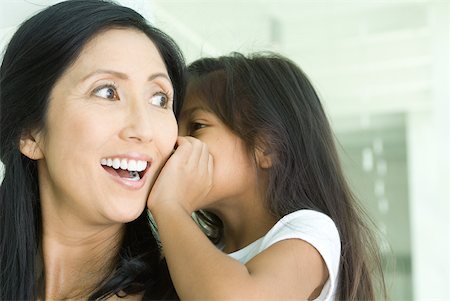 Girl whispering in mother's ear, close-up Stock Photo - Premium Royalty-Free, Code: 632-01785322