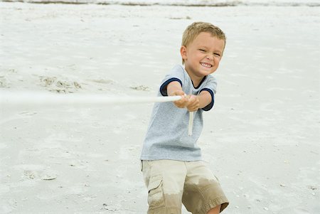 Boy playing tug-of-war, smiling at camera Stock Photo - Premium Royalty-Free, Code: 632-01785339