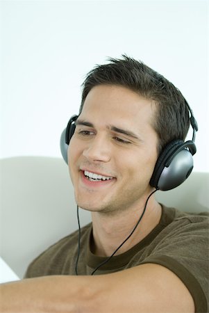 dimpled - Young man wearing headphones, smiling Stock Photo - Premium Royalty-Free, Code: 632-01785472