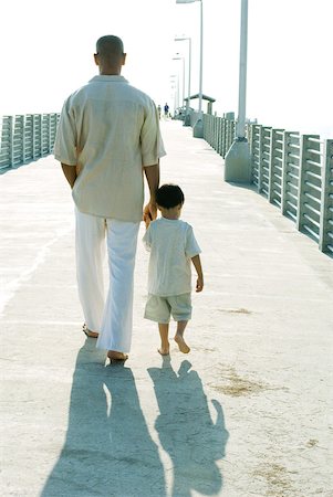 rear view man hands in pocket - Father and son walking together, holding hands, rear view Foto de stock - Sin royalties Premium, Código: 632-01827727