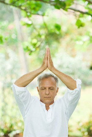 Mature man in prayer position outdoors, arms raised, eyes closed Stock Photo - Premium Royalty-Free, Code: 632-01828158