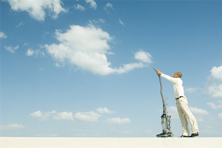 Man vacuuming sky Stock Photo - Premium Royalty-Free, Code: 632-01828523