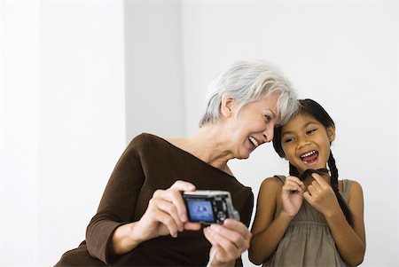 Senior woman photographing self and daughter with digital camera, both laughing Stock Photo - Premium Royalty-Free, Code: 632-02007502