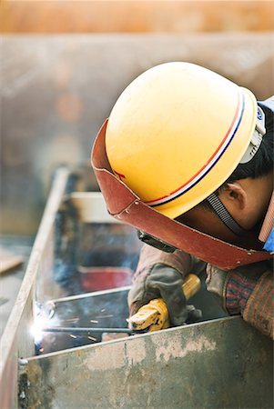 Worker welding metal, side view, close-up Foto de stock - Sin royalties Premium, Código: 632-02038736