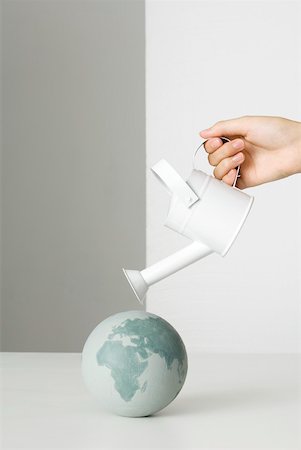 Hand holding watering can over globe Foto de stock - Sin royalties Premium, Código: 632-02128097