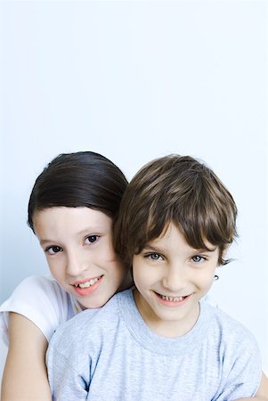 simsearch:632-06029668,k - Sister hugging her brother from behind, smiling at camera, portrait Foto de stock - Royalty Free Premium, Número: 632-02128262