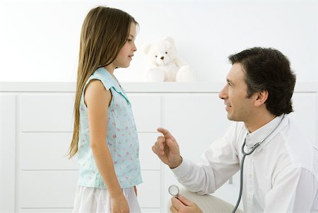 paediatrician (male) - Doctor crouching, explaining something to girl, side view Stock Photo - Premium Royalty-Free, Code: 632-02227635