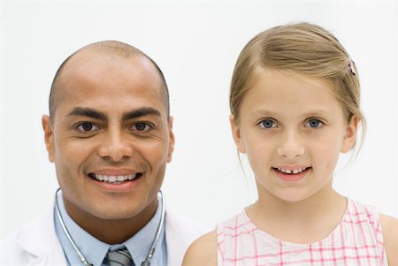 doctor patient friendly - Male doctor beside girl, both smiling at camera, portrait Stock Photo - Premium Royalty-Free, Code: 632-02227656