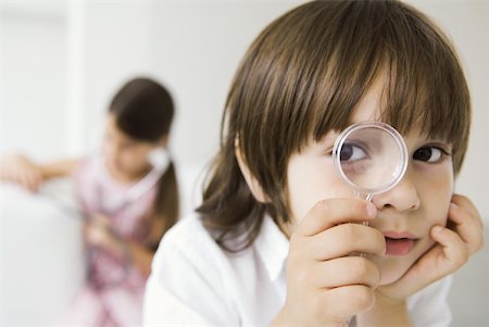 Little boy looking through magnifying glass at camera Stock Photo - Premium Royalty-Free, Code: 632-02227662