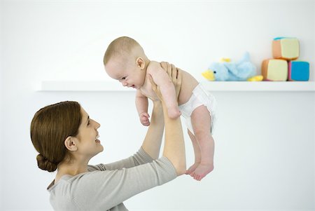 simsearch:6108-06167733,k - Mother lifting baby in the air, both smiling at each other Stock Photo - Premium Royalty-Free, Code: 632-02282491