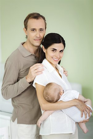 simsearch:695-03390064,k - Parents smiling at camera, woman holding baby, portrait Foto de stock - Sin royalties Premium, Código: 632-02282504