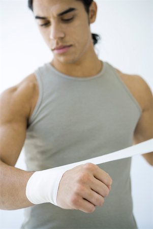 simsearch:695-03390134,k - Man wrapping bandage around his wrist, looking down Stock Photo - Premium Royalty-Free, Code: 632-02282639