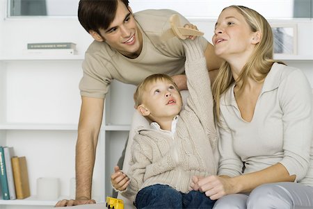 father and son with toy airplane - Little boy playing with toy airplane, parents watching Stock Photo - Premium Royalty-Free, Code: 632-02282889