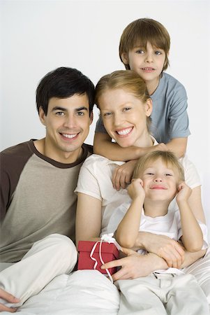 simsearch:632-03027000,k - Family sitting together, smiling at camera, mother holding gift Fotografie stock - Premium Royalty-Free, Codice: 632-02282881