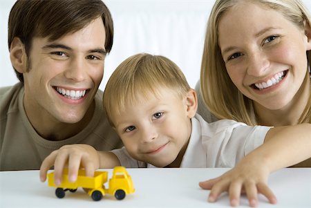 simsearch:632-02282914,k - Family smiling at camera, boy playing with toy truck Stock Photo - Premium Royalty-Free, Code: 632-02282916
