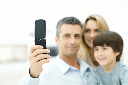 simsearch:632-02345141,k - Famille regardant téléphone portable ensemble, mettre l'accent sur le téléphone Photographie de stock - Premium Libres de Droits, Code: 632-02282981
