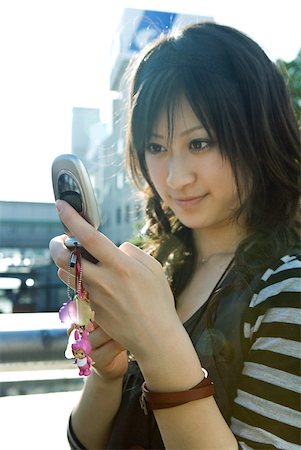 pulsera - Young Japanese woman looking at cell phone Foto de stock - Sin royalties Premium, Código: 632-02344448