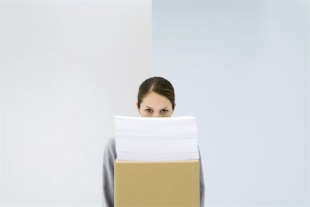 Woman peeking over stack of paper on top of cardboard box Stock Photo - Premium Royalty-Free, Code: 632-02344719