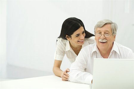 simsearch:633-02345800,k - Senior man and mid-adult woman looking at laptop together, smiling Stock Photo - Premium Royalty-Free, Code: 632-02344937