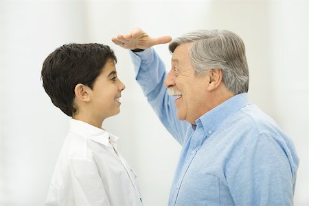 simsearch:614-07146506,k - Grandfather comparing height with grandson, smiling at each other Foto de stock - Sin royalties Premium, Código: 632-02344991