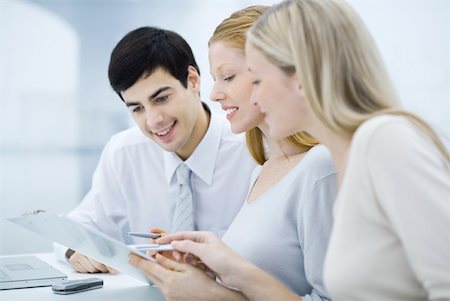 female team of three - Three colleagues reading document on clipboard, smiling Stock Photo - Premium Royalty-Free, Code: 632-02345141