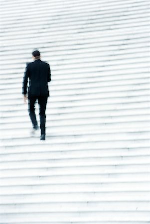 Businessman ascending stairs outdoors Stock Photo - Premium Royalty-Free, Code: 632-02345347