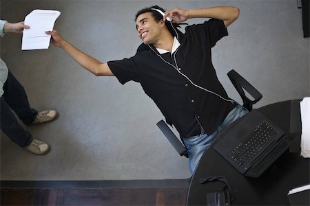 Young office worker leaning back in chair to receive document from colleague, high angle view Stock Photo - Premium Royalty-Free, Code: 632-02644871